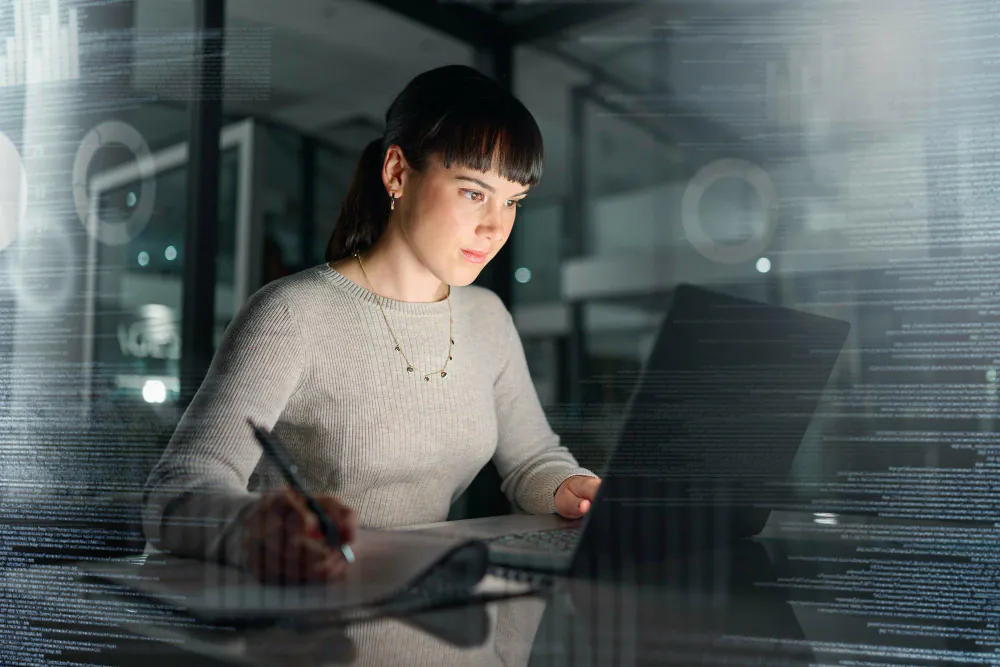 Woman working on a laptop in a hybrid working office.